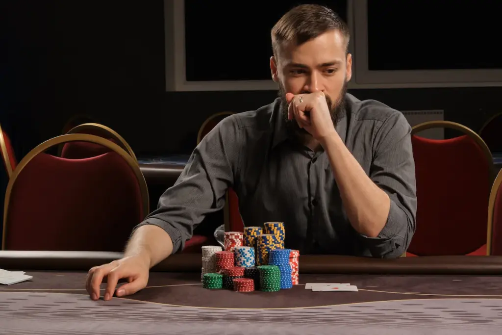 poker player analyzing opponent behavior at table live poker tells