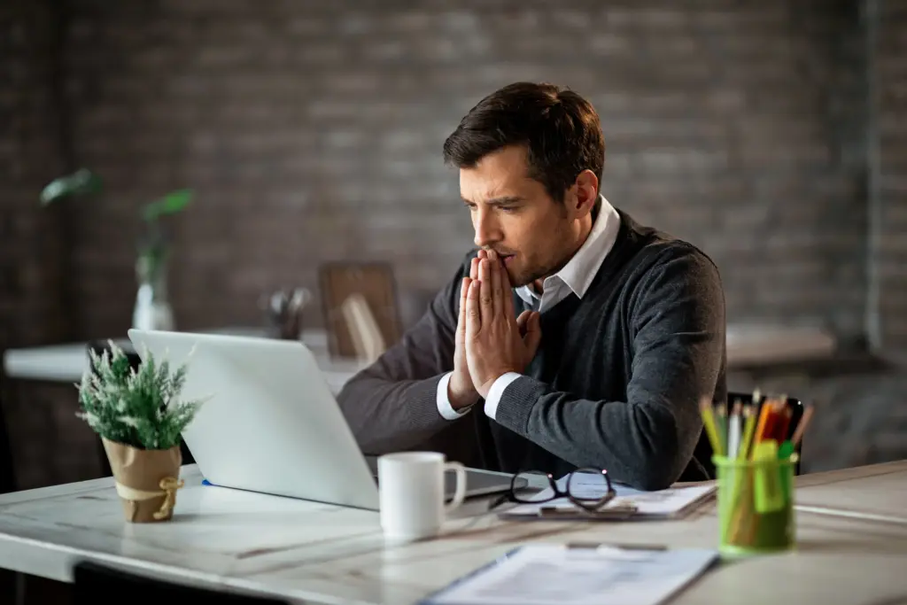 A thoughtful online poker player looking at his laptop screen, highlighting the need for poker discipline.