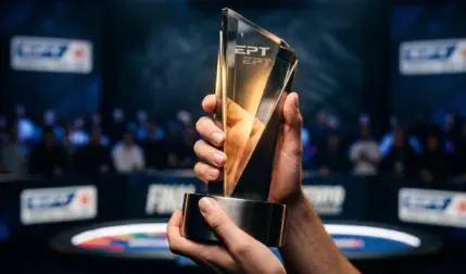 An AI-generated, high-quality close-up photo of Roman Stoica's hands holding the 2026 EPT Monte Carlo Main Event trophy. The blurred background shows the tournament arena with 'EPT' logos.