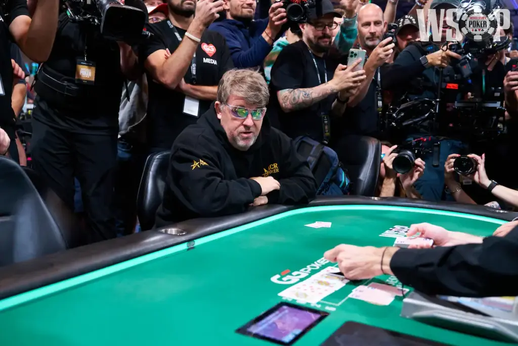 Chris Moneymaker seated at the 2026 WSOP Main Event bubble as photographers gather around the table.